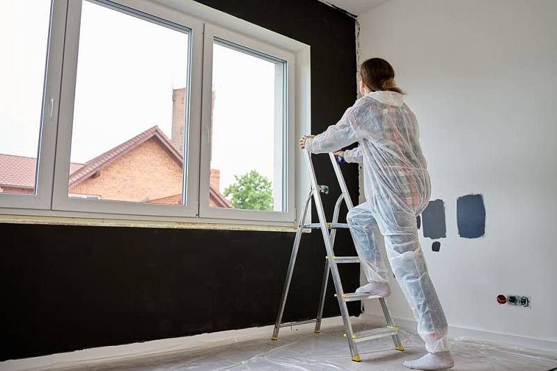 Woman,In,Protective,Wear,Climb,Ladder,With,Paint,Roller,In