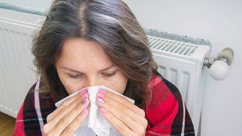 nachlazená žena u radiátoru