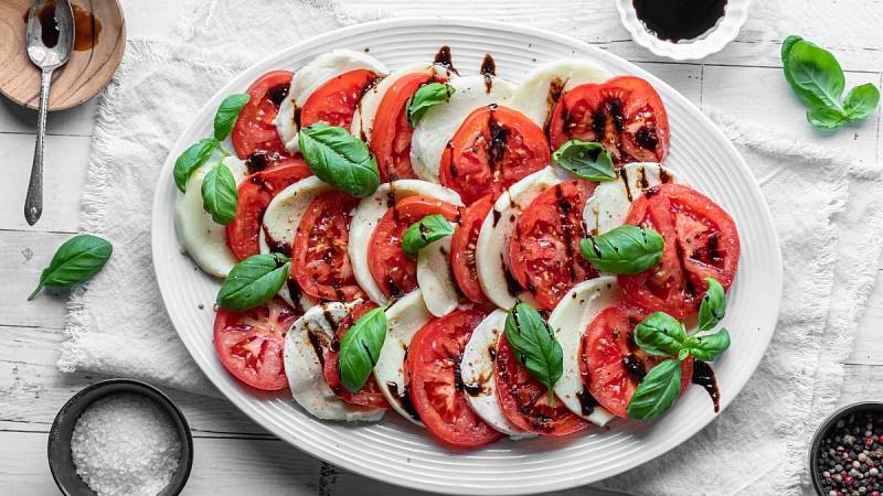 Caprese salát pokapaný balzamikovou glazurou připravenou k servírování.